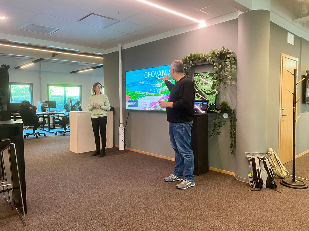 Two project participants presenting the game on a big screen television