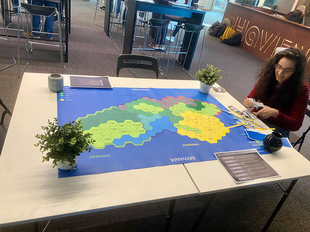 One project participant sitting by a table with a map of Geovania.
